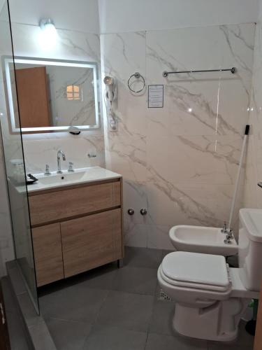 a bathroom with a sink and a toilet and a mirror at CASABLANCA CATAMARCA Guest House in San Fernando del Valle de Catamarca