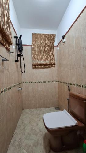a bathroom with a toilet and a shower at Joyous Cottage in Maharagama