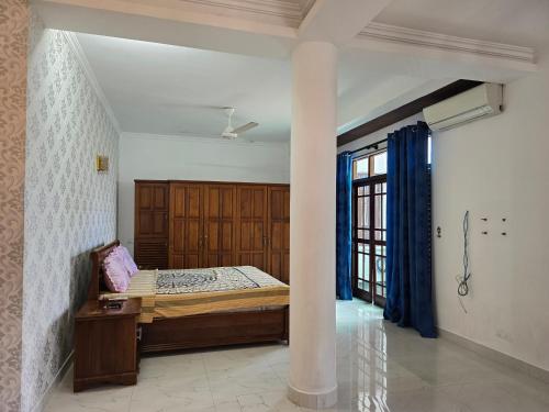 a bedroom with a bed in a room with a column at Joyous Cottage in Maharagama