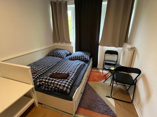 a small bedroom with a bed and a chair at Private Room in Oldenburg with Balcony in Shared Apartment in Hundsmühlerhöhe