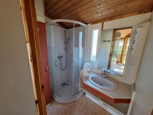 a bathroom with a shower and a sink at Camping Verte Rive in Saint-Laurent-de-Cerdans