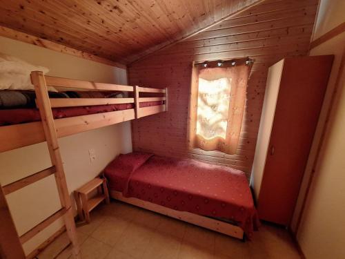 a small room with a bunk bed and a window at Camping Verte Rive in Saint-Laurent-de-Cerdans