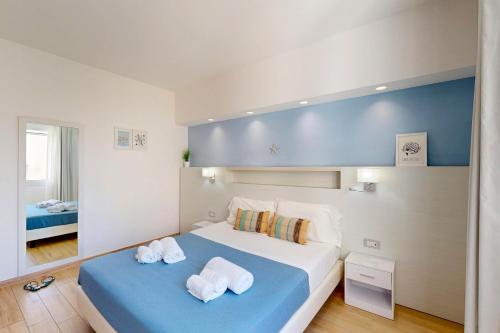a bedroom with a large bed with towels on it at Hotel Perla Gaia in San Vito lo Capo