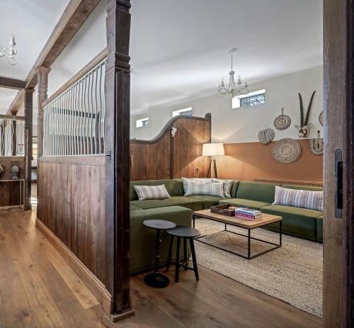 a living room with a green couch and a table at The Lady Rothschild Stables in Peterborough