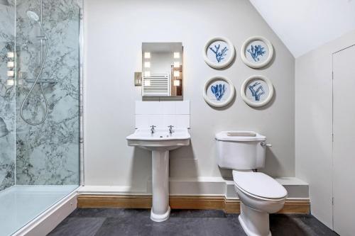 a bathroom with a toilet and a sink and a shower at The Lady Rothschild Stables in Peterborough