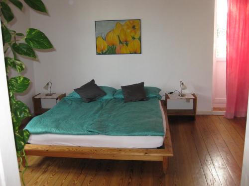 a bedroom with a bed with a green blanket at Ferienwohnung Gutzeit in Flensburg