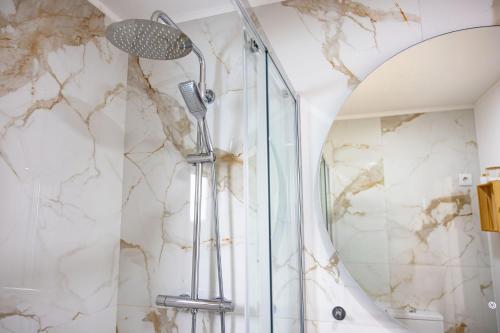 a shower in a bathroom with a marble wall at Casa d'Arcã in Alijó