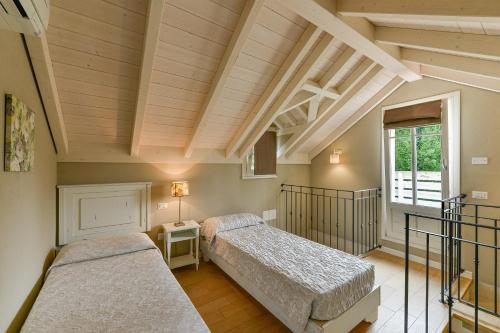 two beds in a room with wooden ceilings at Conero Azzurro in Numana