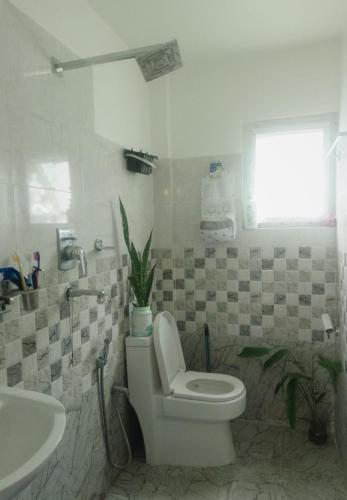 a bathroom with a toilet and a sink at Kiyo's Apartment in Bālāju