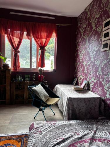 a bedroom with two beds and a chair and a window at Kiyo's Apartment in Bālāju