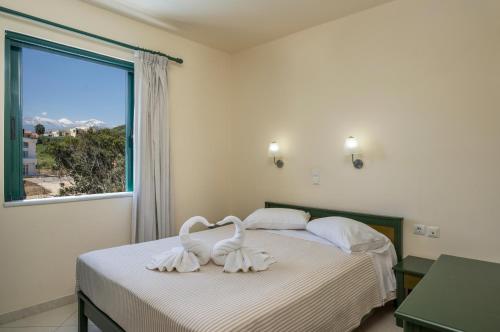 two beds in a room with a window at Gianna Apartments in Almyrida