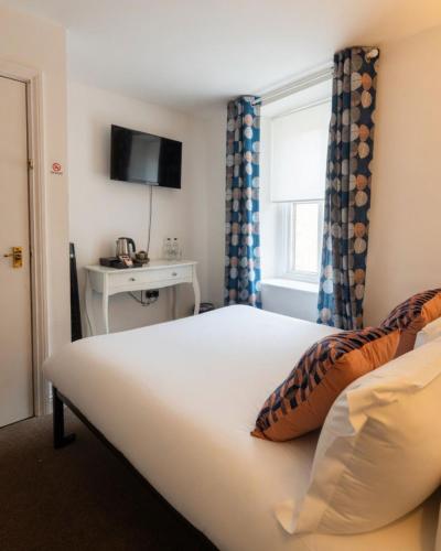 a bedroom with a bed with a window and a television at The Hairy Lemon in Alnwick