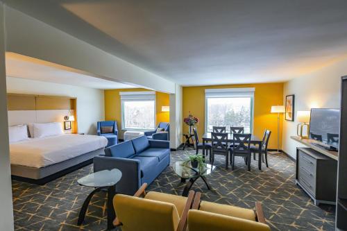 a hotel room with a bed and a dining room at Holiday Inn - Piscataway - Somerset by IHG in Piscataway