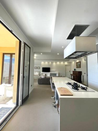 a kitchen with a white counter and a living room at Deluxe Appartment in Cinisi