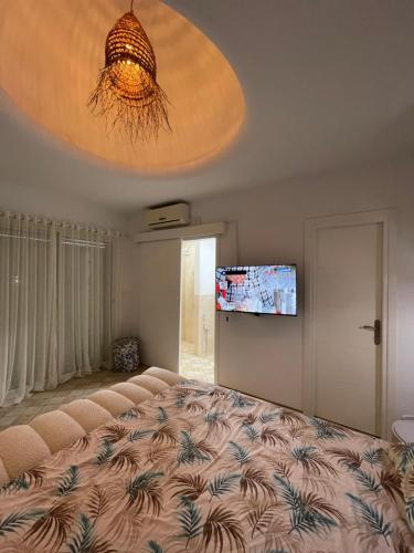 a bedroom with a large bed and a flat screen tv at Villa avec Piscine Privée à Djerba Dar Jafra in Houmt Souk