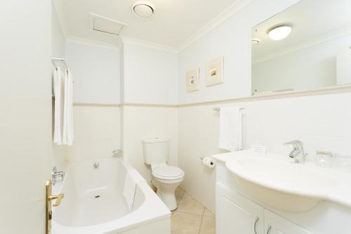 a white bathroom with a sink and a toilet at The Stellenbosch Hotel in Stellenbosch