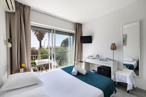 a hotel room with a bed and a balcony at Hotel Le Golfe Bleu in Cavalaire-sur-Mer