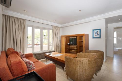 a living room with a couch and a table and chairs at The Stellenbosch Hotel in Stellenbosch