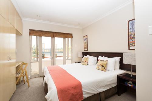 a bedroom with a large bed and a balcony at The Stellenbosch Hotel in Stellenbosch