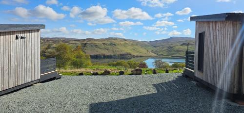 a view of a lake from between two buildings at Croft Seven Cabins in Port na Long
