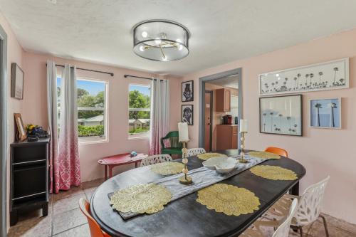 a dining room with a black table and chairs at Bright 3BR, Dogs, Fenced Yard, FSU & Dwntown in Tallahassee