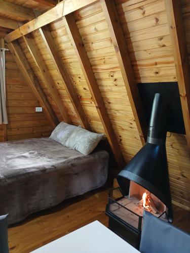 a bedroom with a bed and a fireplace at Chalés Snow in Urubici