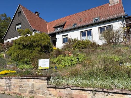 a white house with a sign in front of it at Ferienwohnung Baumkrone in Waldeck