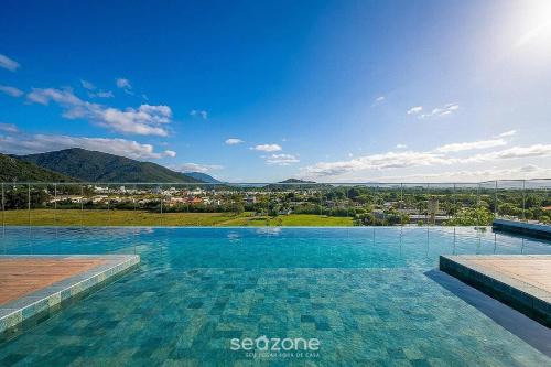 a large swimming pool with a view of a city at Cozy Studios in Floripa - OKA in Florianópolis
