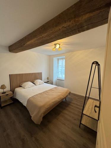 a bedroom with a large bed and a wooden floor at L'hotel de ville in Chéroy