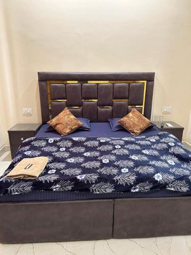 a bed with a blue comforter and pillows on it at Hotel LD Empire in Amritsar