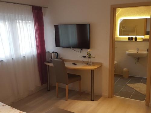a room with a desk with a television on the wall at Steakhüsli Hotel- Restaurant in Schopfheim