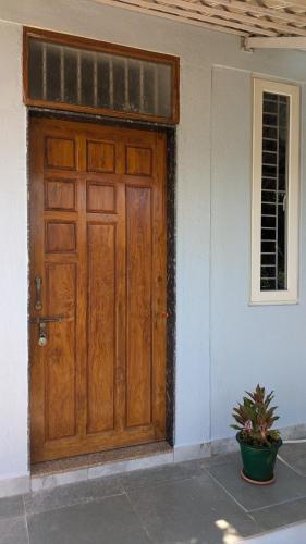 a wooden door of a house with a potted plant at Mrinal Homestay in Ponda