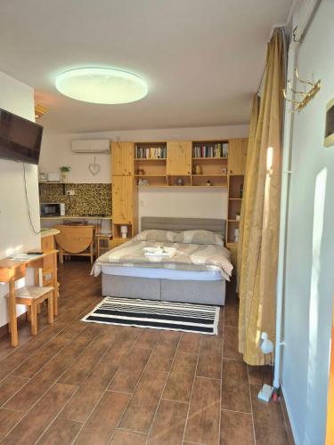 a bedroom with a bed and a table and a desk at Sárréti Apartmanház in Balatonfüred