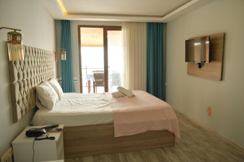 a bedroom with a large bed and a window at Pasha Tatil Köyü in Akcaabat