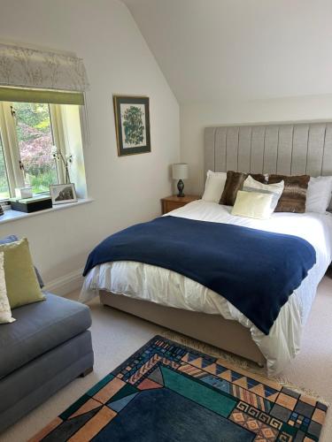 a bedroom with a large bed and a couch at Bourne House in Mursley