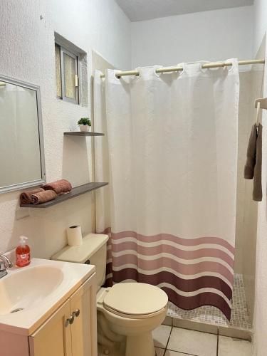 a bathroom with a toilet and a shower curtain at Villa Gael Vacation Home in La Paz