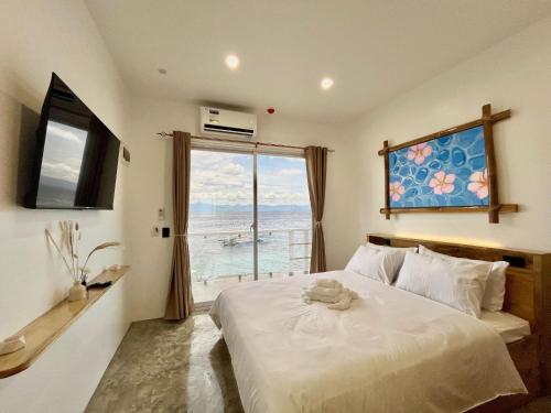 a bedroom with a bed and a large window at Antuwanga reef resort in Moalboal