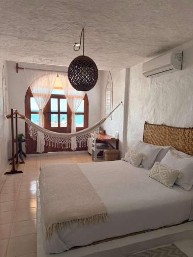 a bedroom with a large white bed and a window at Suites Al Mar, en el malecón de San Cristóbal in San Cristóbal