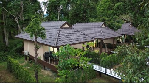 a house with black roof in a forest at Khaosok Unseen Resort in Khao Sok National Park