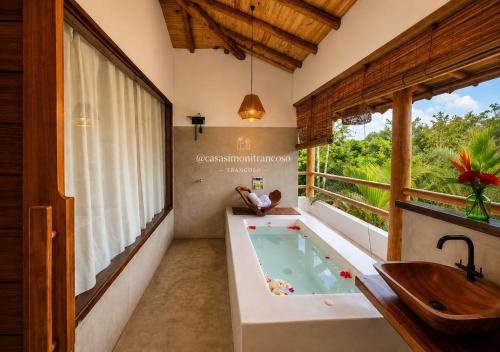 a bathroom with a tub and a sink at CASA SIMONI Trancoso in Trancoso