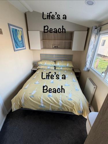 a bedroom with a bed with words life is a beach at Lifes a Beach on Presthaven Sands in Prestatyn