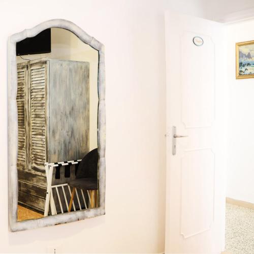 a mirror hanging on a wall next to a chair at La Stellina Capri in Capri