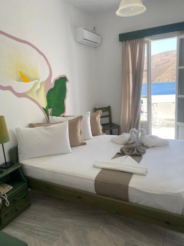 a bedroom with a large bed with a large window at Pelagos in Aegiali