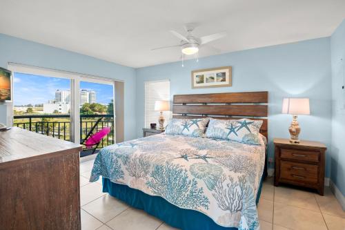 a bedroom with a bed and a balcony at Gulf Strand Resort by Travel Resort Services in St. Pete Beach