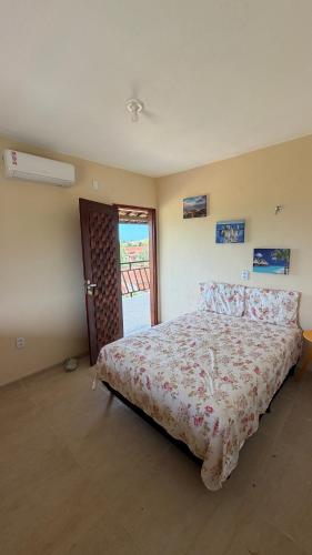a bedroom with a bed with a floral bedspread at Casa da Duna Moitas-Icaraizinho de Amontada Ceará in Praia de Moitas