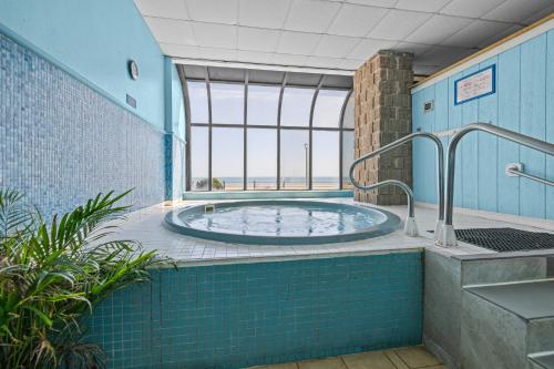 a hot tub in a room with a window at The Barclay Towers Hotel and Resort in Virginia Beach