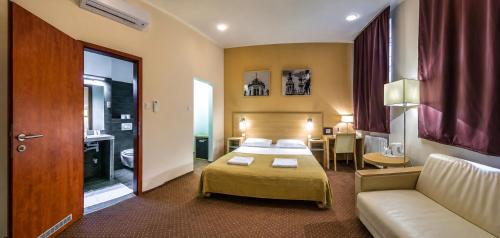 a hotel room with a bed and a couch at Budapest Citi Guesthouse - contactless self check in in Budapest