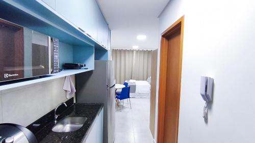 a room with a kitchen with a sink and a microwave at Acqua Beach Residence by CTA in Tamandaré