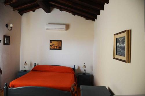 a bedroom with a bed with a red blanket at Agriturismo Arona in Sperlinga