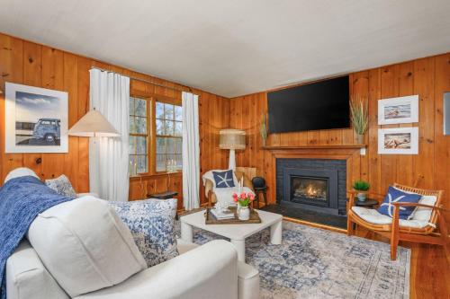 a living room with a white couch and a fireplace at The Coast: Cozy Cape Escape in Dennis Port in Dennis Port